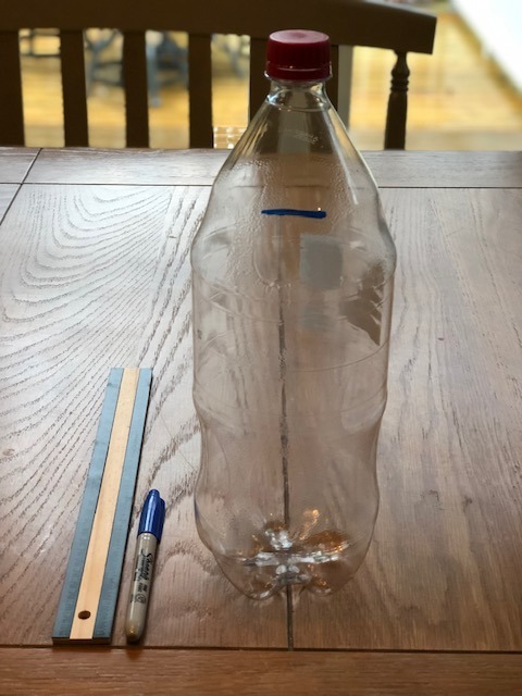 plastic liter bottle standing beside ruler and marker